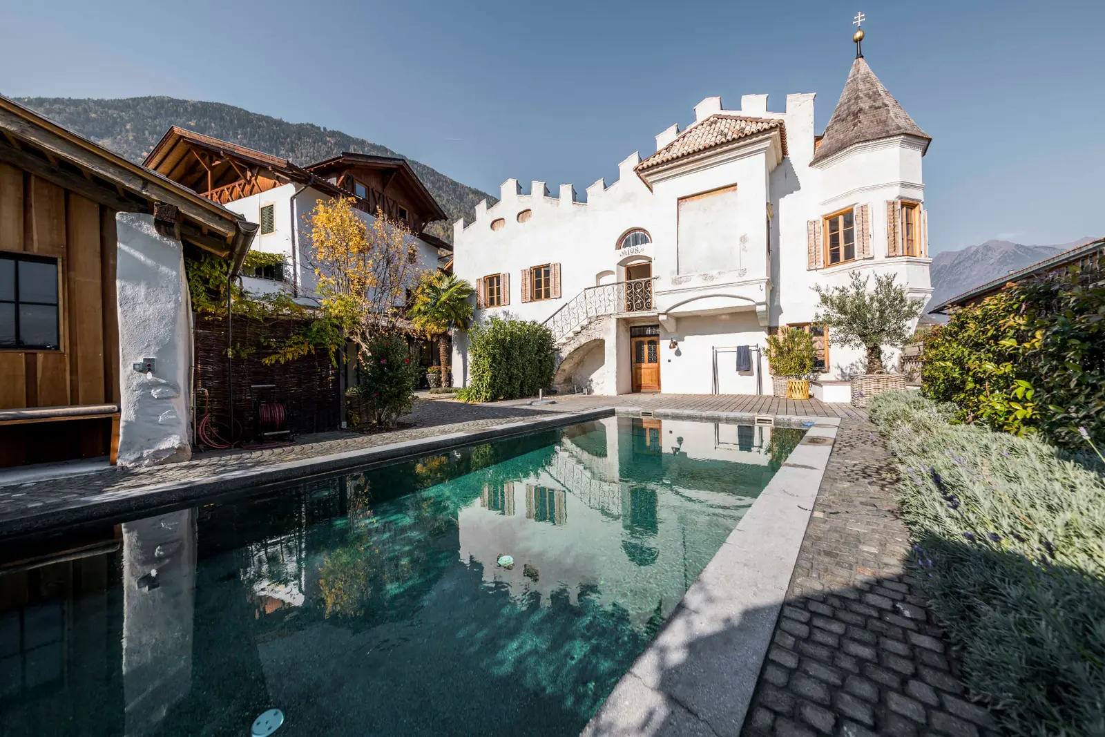 Oberplattnerhof Tscherms — historischer Ansitz mit Zinnenmauer, Turm und Pool im Innenhof